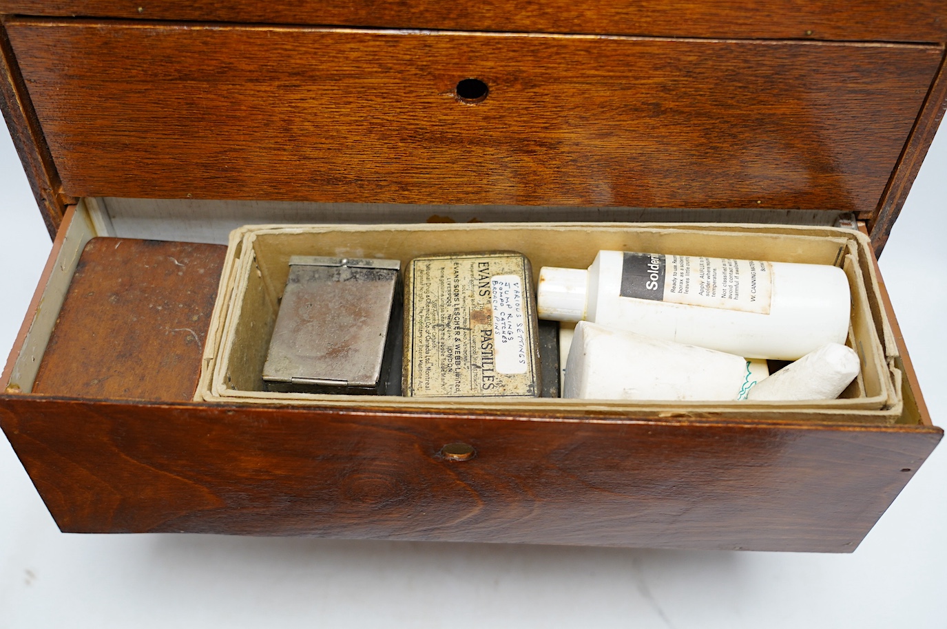 A collection of watch parts, tools and a small selection of costume jewellery, housed in two cases, together with two books. Condition - poor to fair